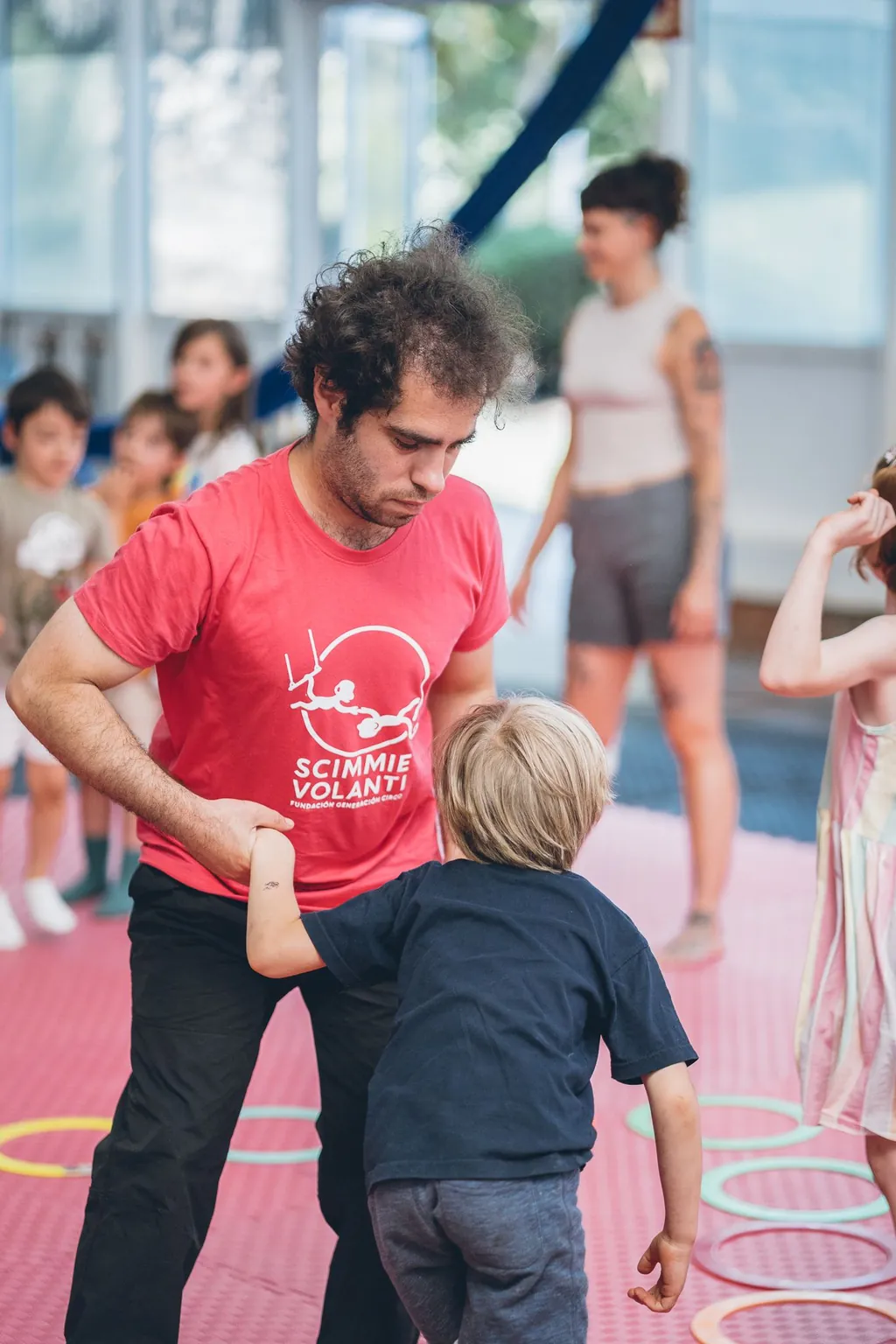 Una profesora ayuda a un niño pequeño a mantener el equilibrio.